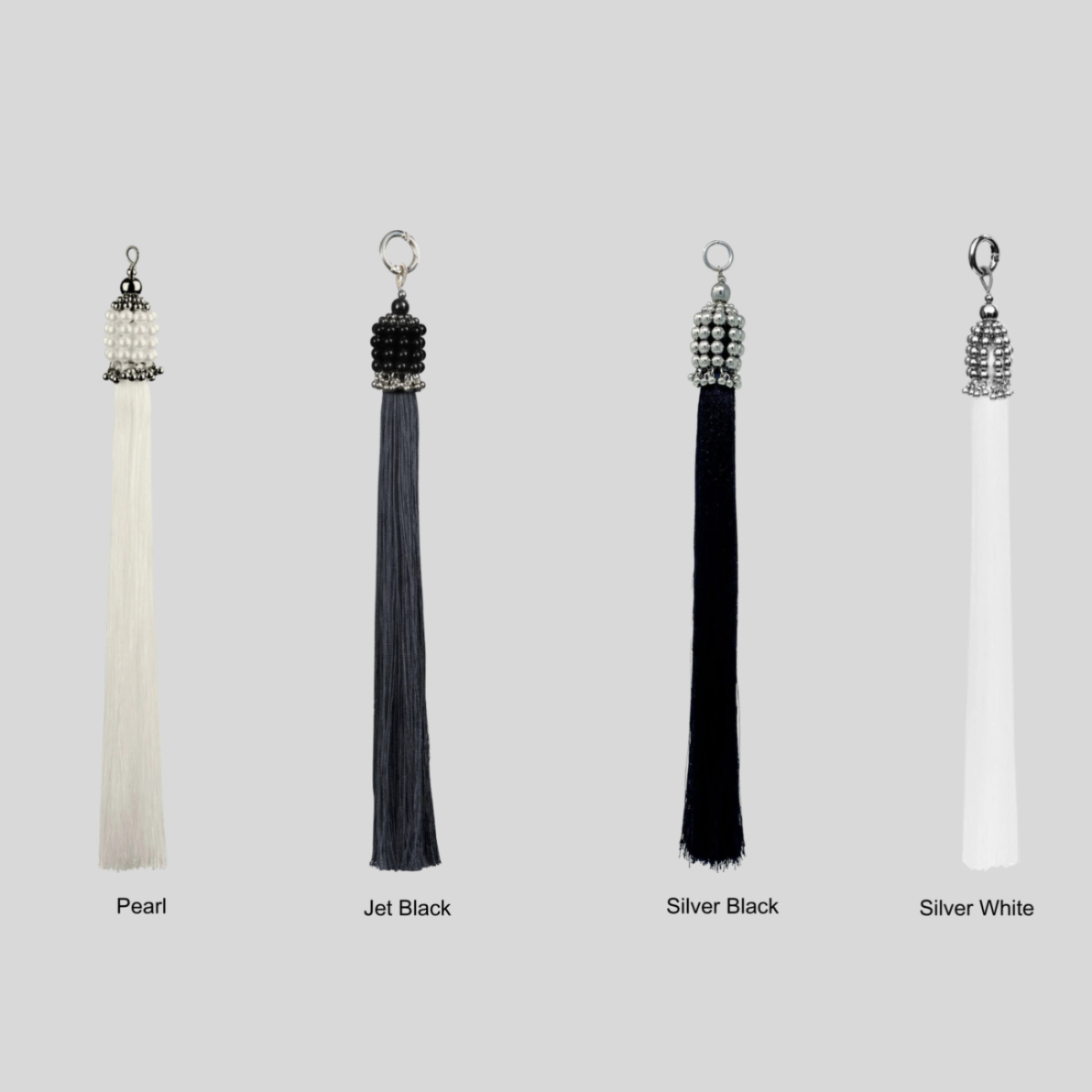 Set of four tassels in different colors with siver, pearl, and black crsytal beads on a grey background by Object&amp;Dawn