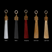 Set of five tassels in different colors with gold beads on a black background by Object&Dawn