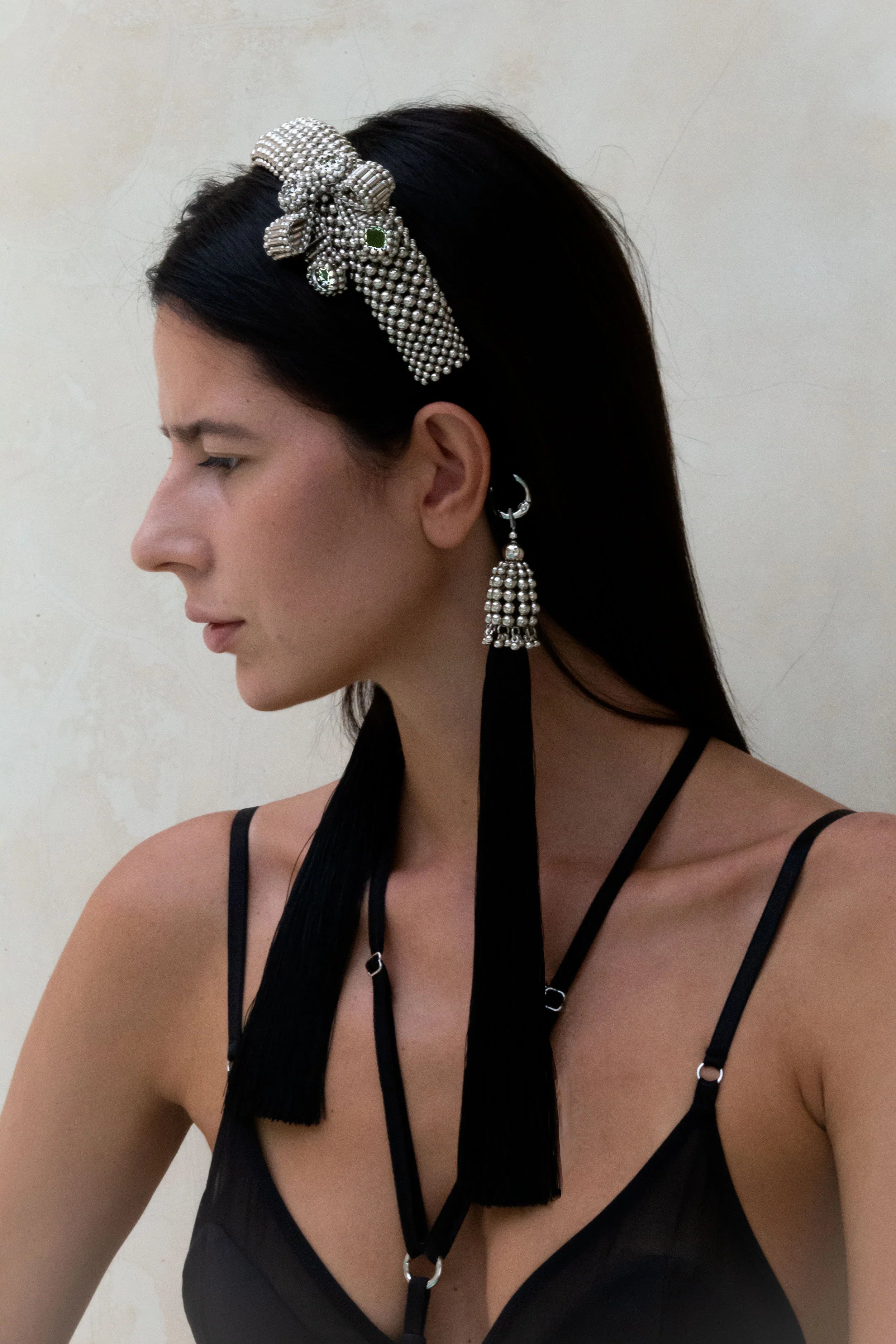 Woman in black outfit wearing Silver Beaded Amaya Headband with tassels by Object &amp; Dawn in neutral background