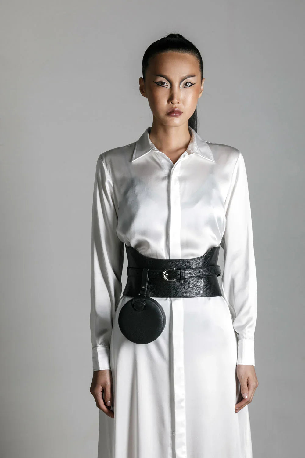 woman in white shirt dress wear zheng coin bag and corset belt by object and dawn close up in netural background