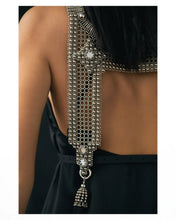 Woman wearing a black dress with silver beaded top and matching choker necklaces on white background close up 