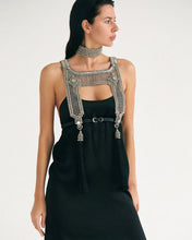 Woman wearing a black dress with silver beaded top and matching choker necklaces on white background