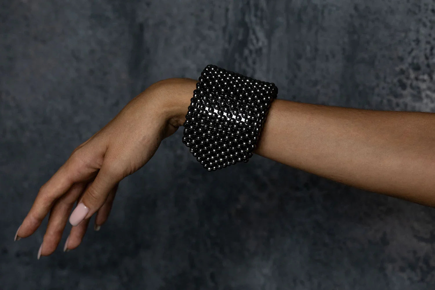 Object & Dawn beaded wrist accessory in ivory, structured supple cuff with polymer metal beads, ghost image side worn view