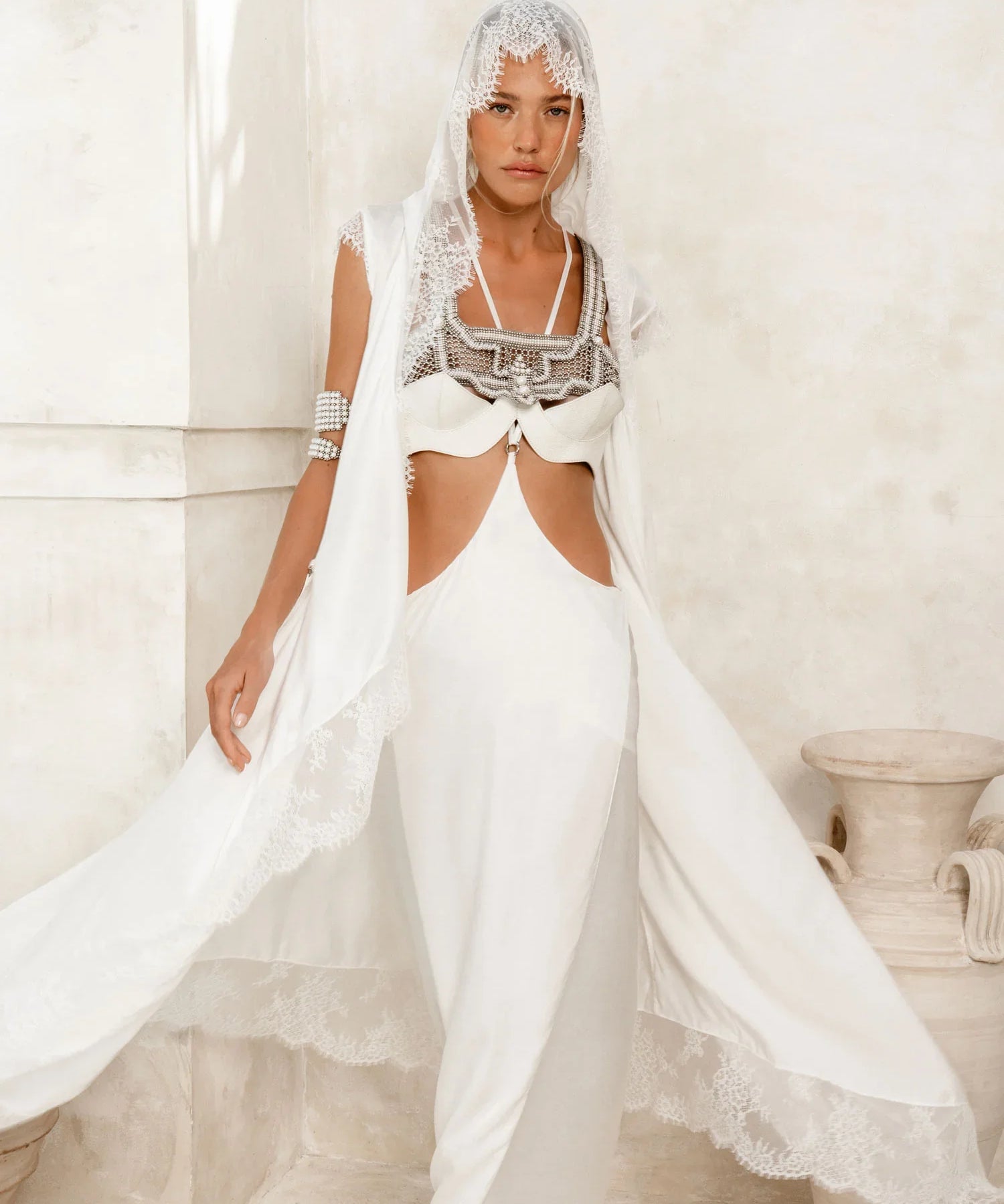 woman wear bride oufit in white robe lace with handcrafted modular beads crown and harness in pearl by object and dawn