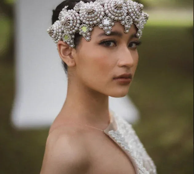Woman wearing a decorative headpiece with a blurred outdoor background