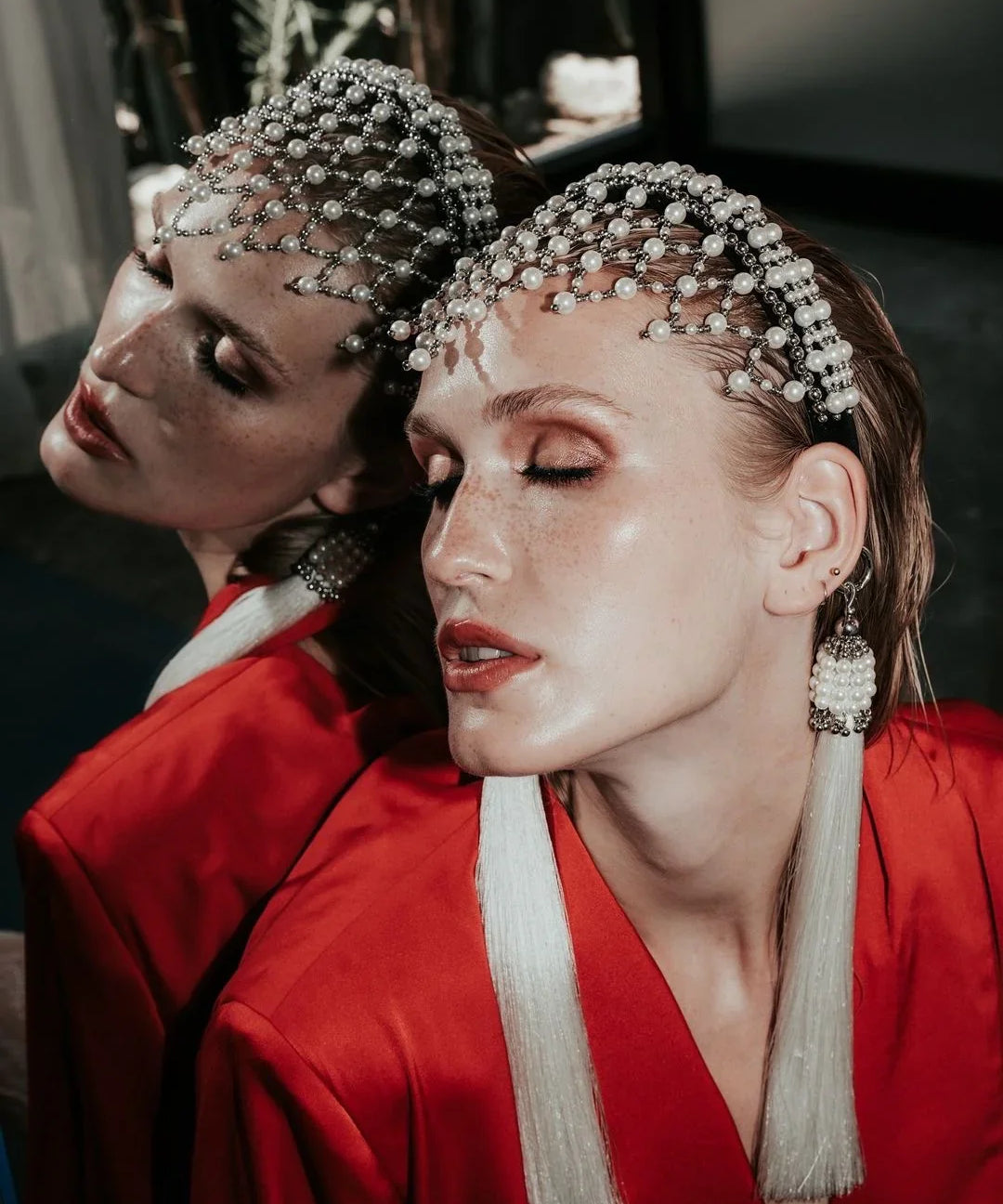Woman wearing a red outfit with decorative freja headband against a mirror background