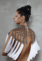 Beaded handcrafted polyester tassel by silver coated metal beads on Freja modular cape in silver on grey background
