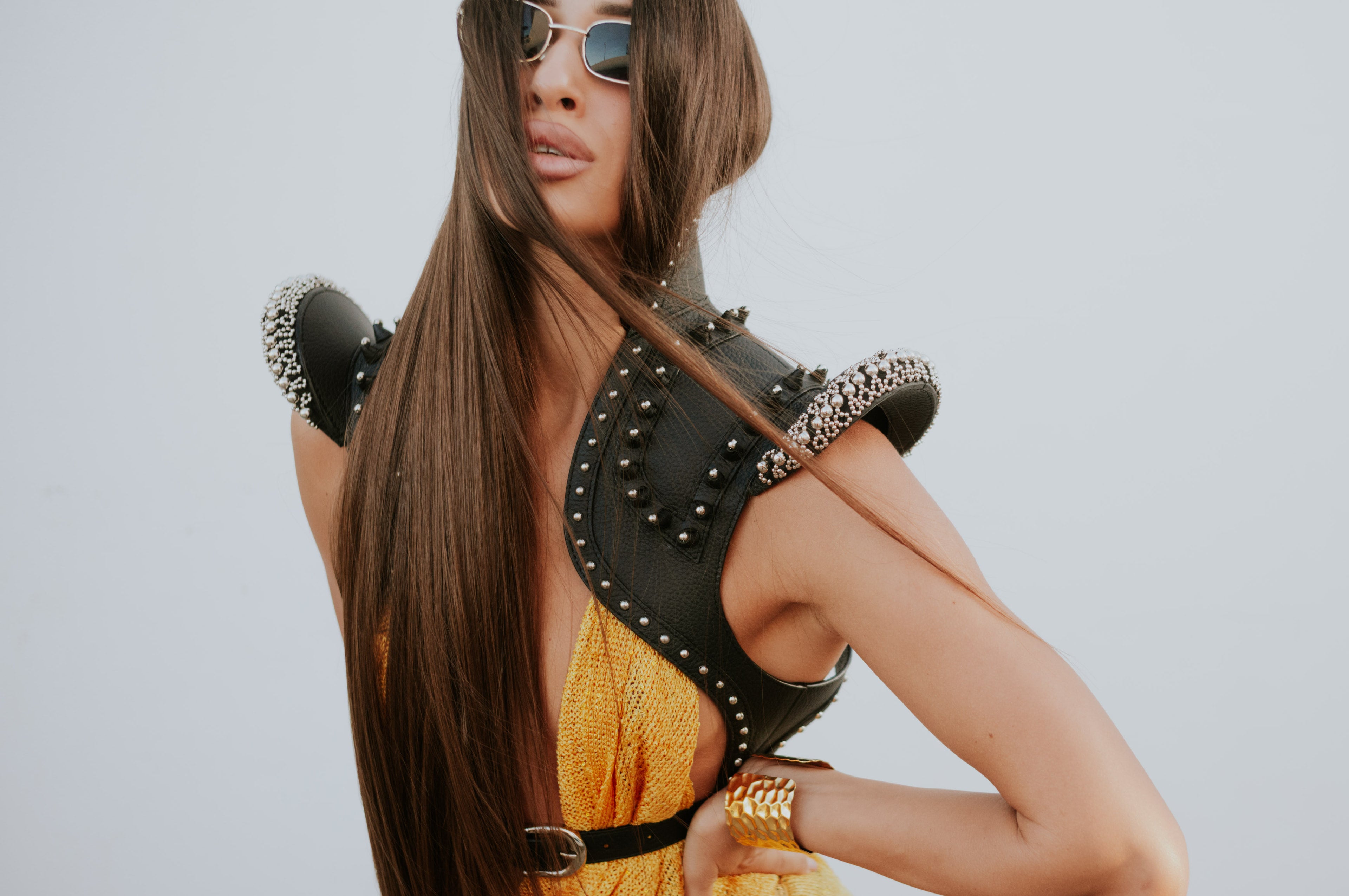 woman in orange dress wears helios leather bolero in white background