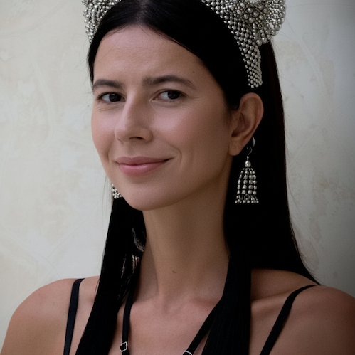 A woman with black long hair wearing Tamoe SIlk Harness Skirt and a jas headband in silver by Object&Dawn