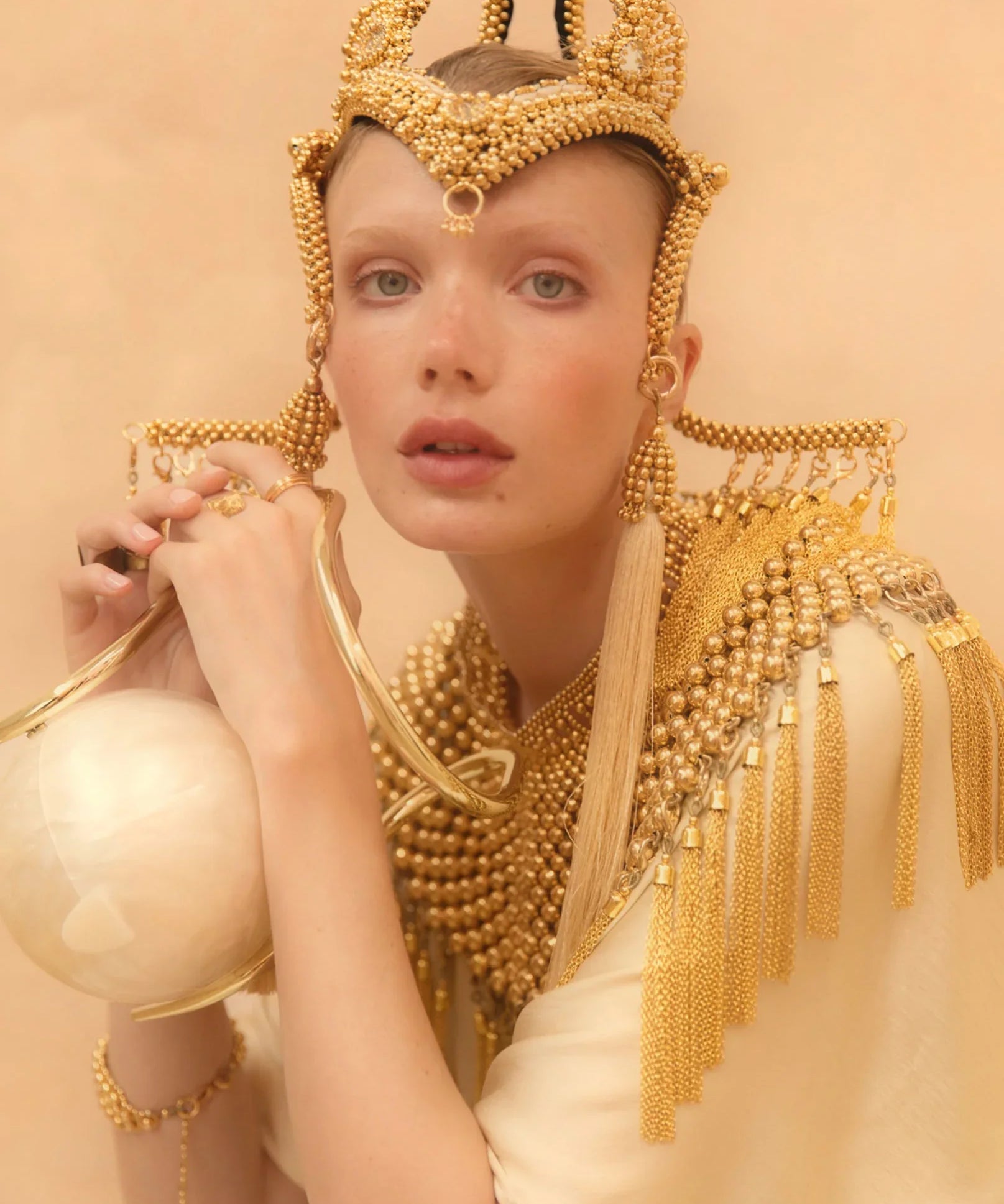 Jolina with handcrafted modular jas headpiece system with 22k gold wash on polymer beads with removable tassels on gold background