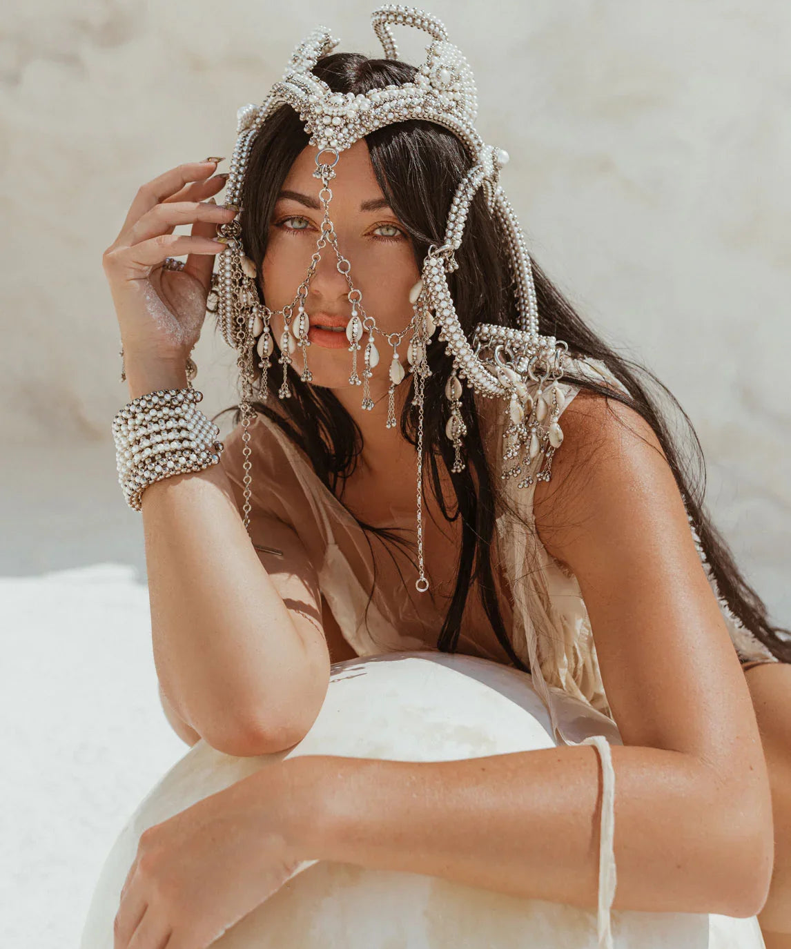 woman in white background with modular headpiece system in pearl with removable mask and pearl cowrie tassels in grey background, ghost image front by Object&Dawn