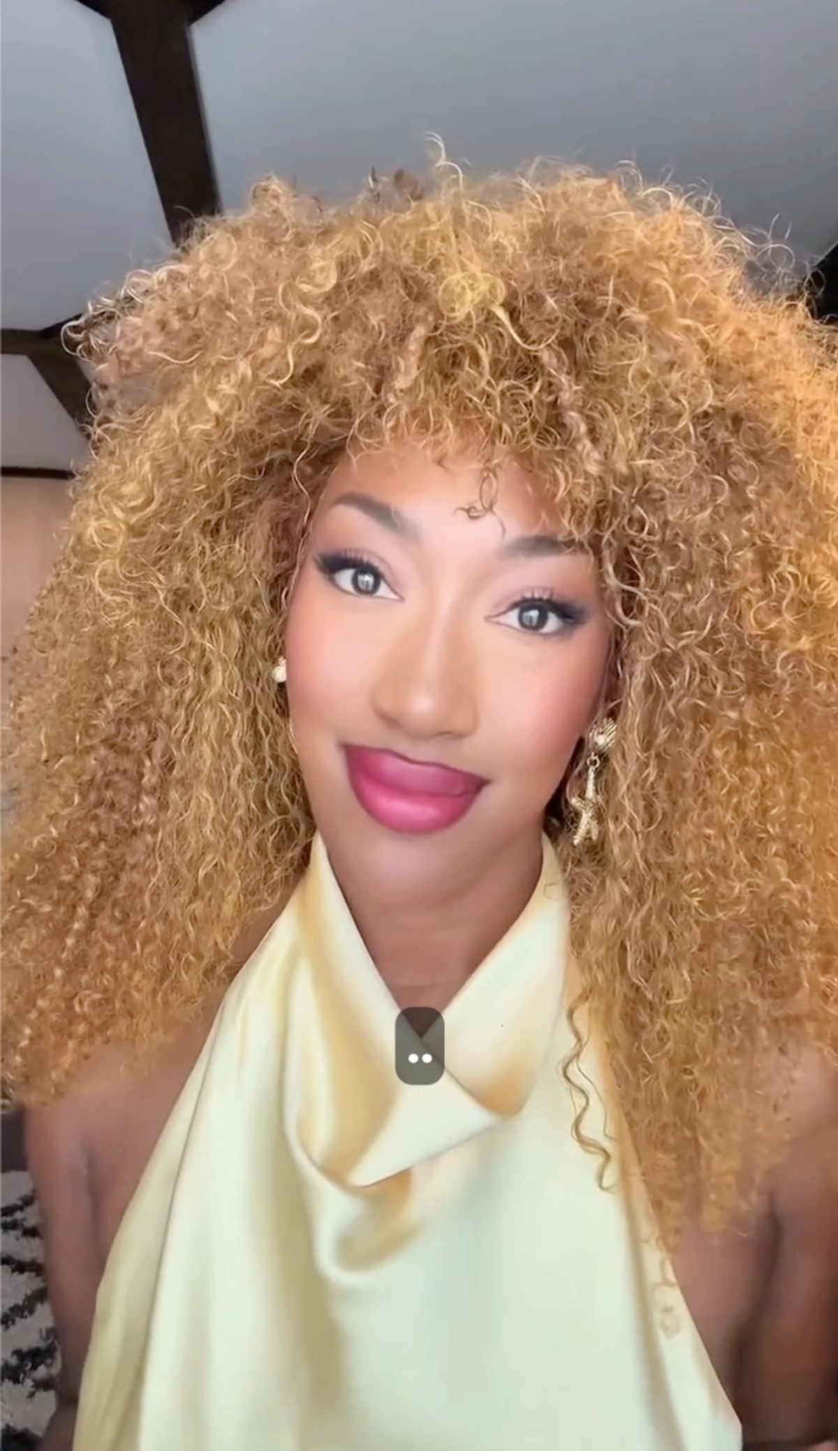 Woman with blonde curly hair wearing a yellow top indoors by Object & Dawn.