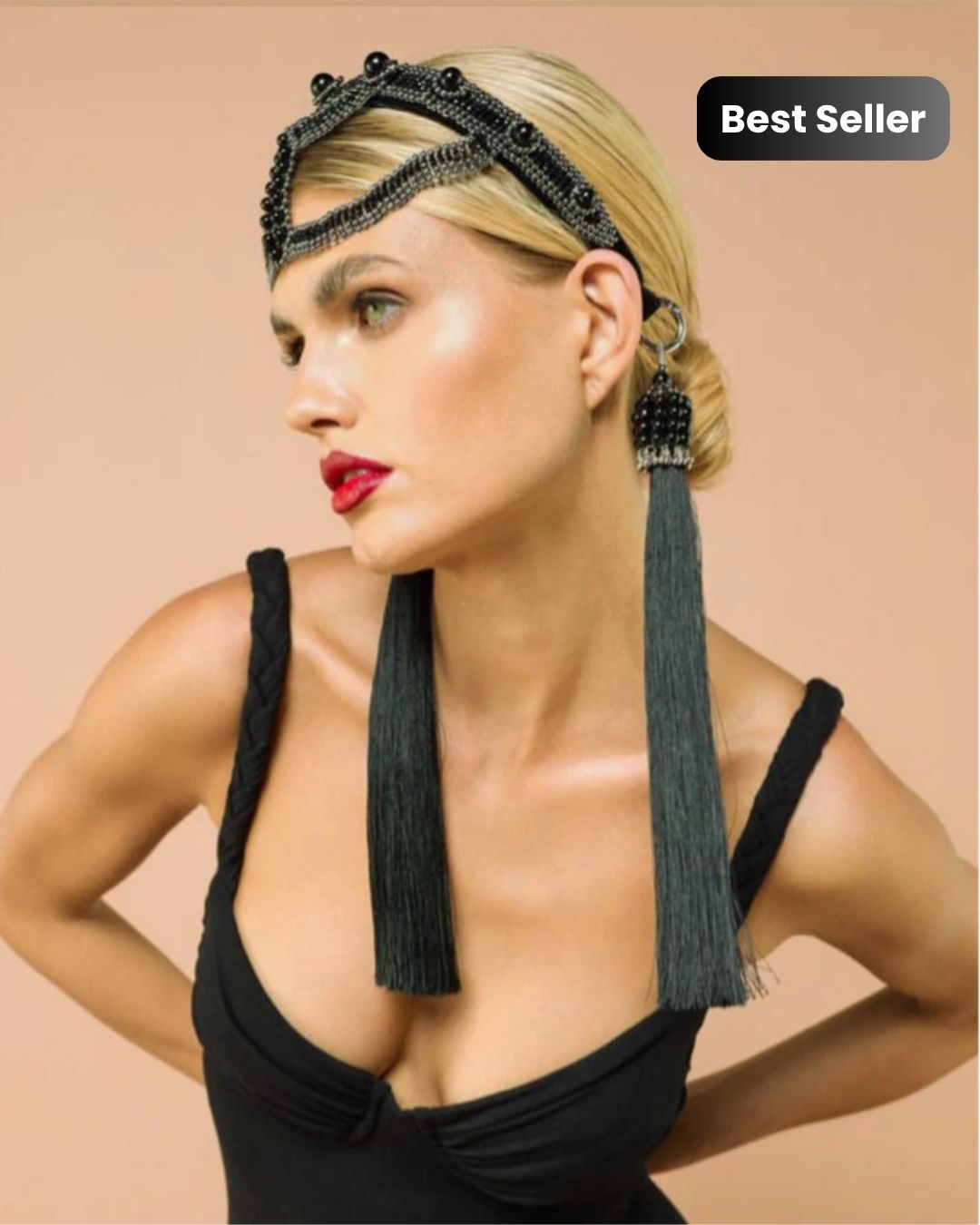 Woman wearing a black headpiece with tassels on a beige background