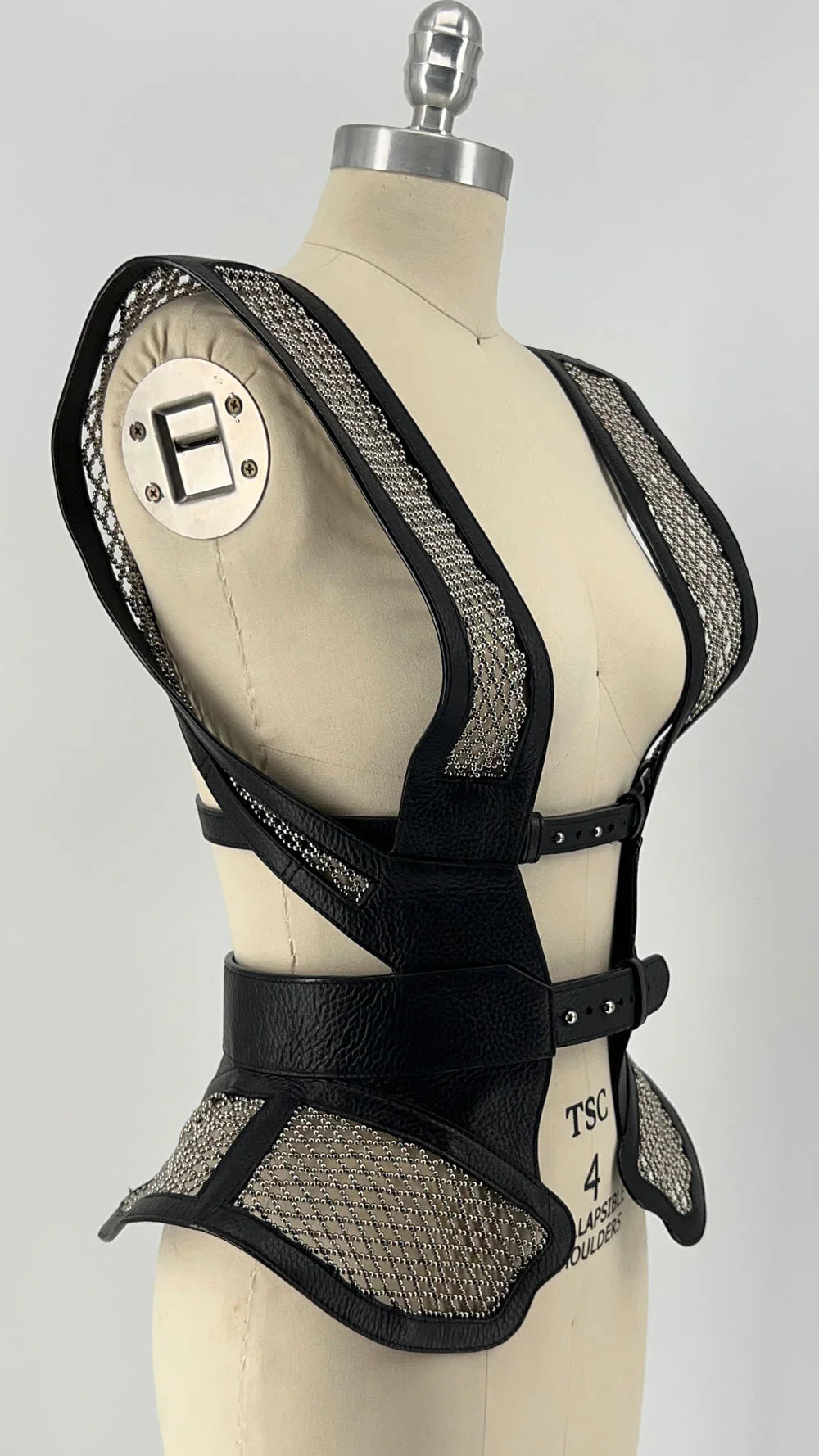 Black beaded mesh and leather top on a mannequin diagonal view