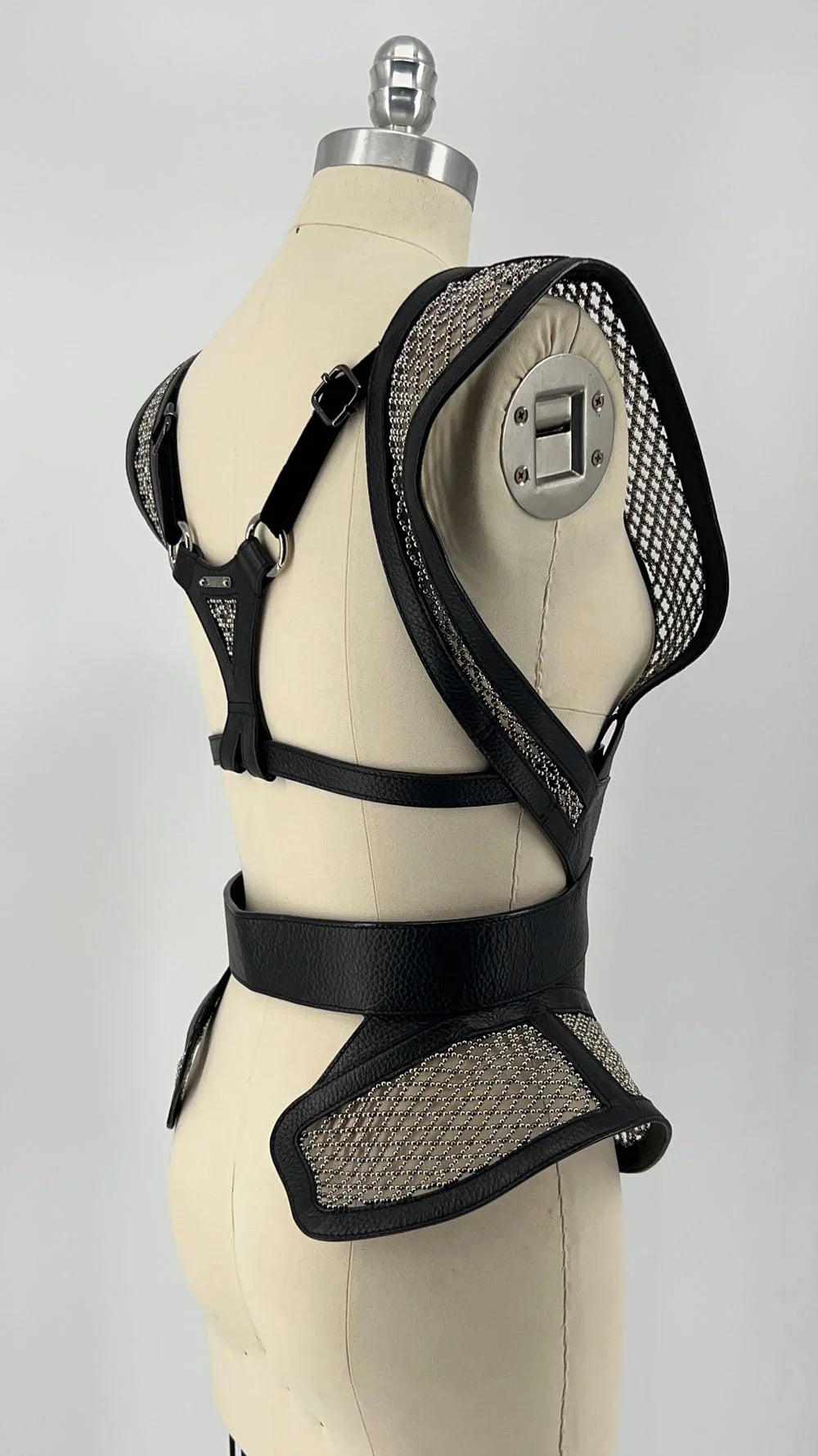 Black beaded mesh and leather top on a mannequin diagonal back view
