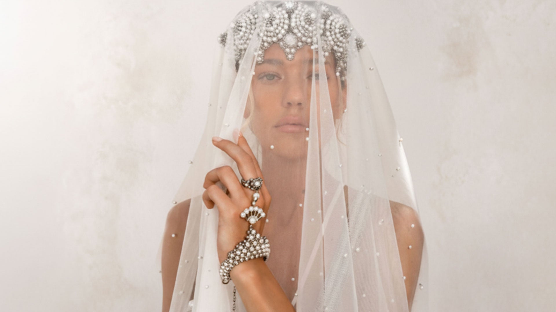 Woman wearing Eingana Crowm and veil with Mata Hari Jewlery by Object &amp; Dawn on a plain background