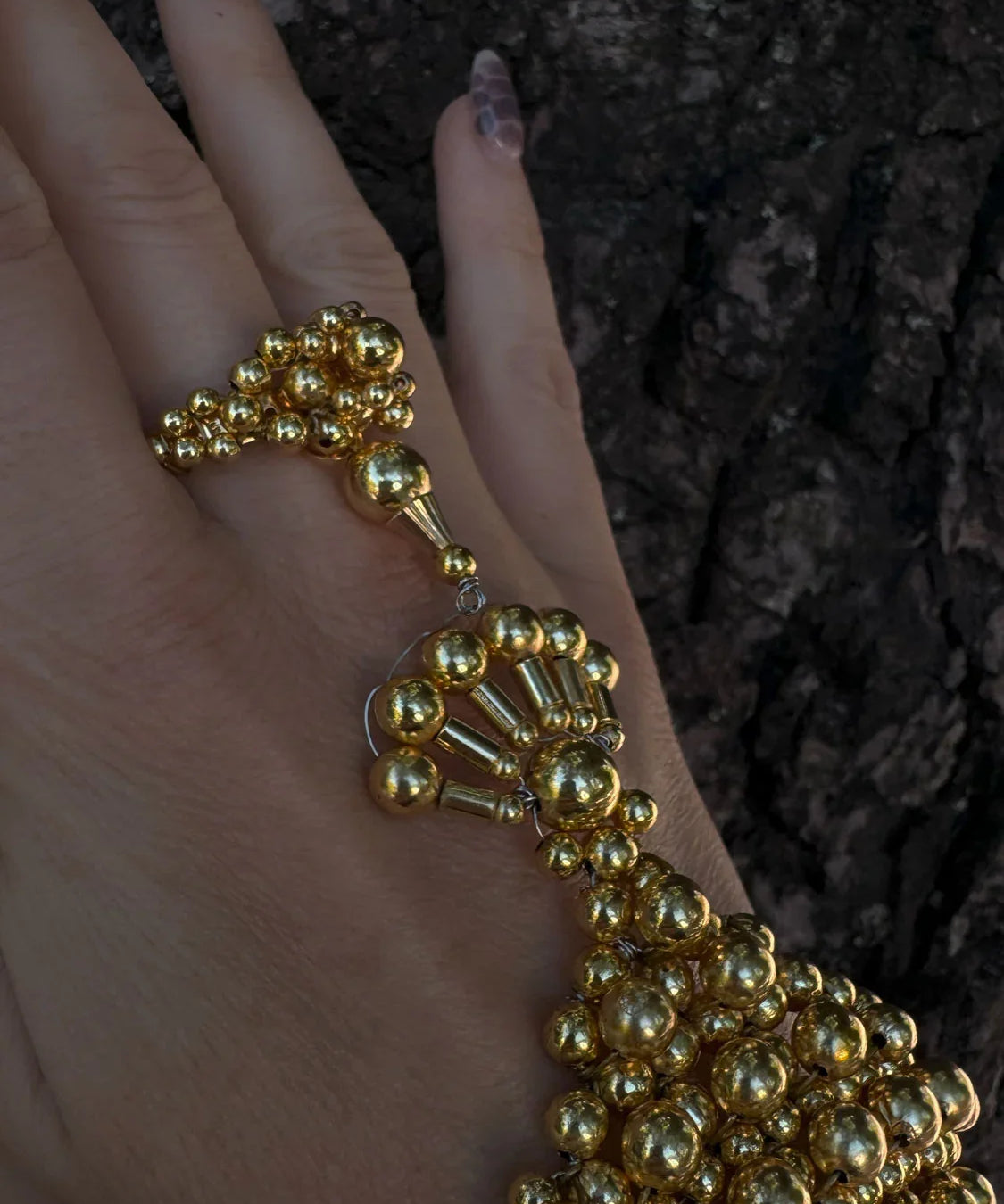 beaded detail of modular hand jewelry and ring in gold by object and dawn close up