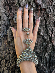 handcrafted mata hari ring silver on hand in wood background by object and dawn front view