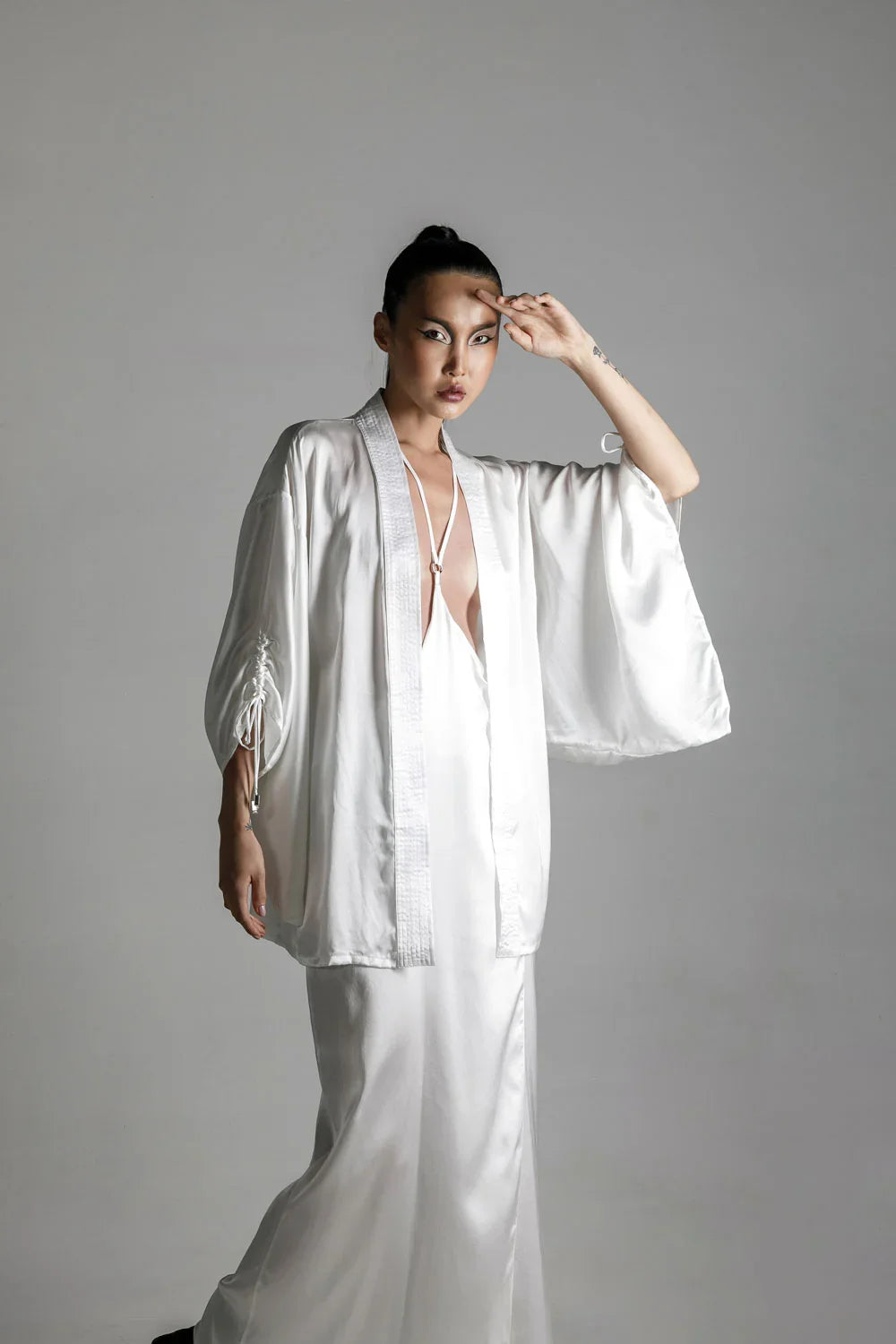 short white silk kimono with white harness skirt worn view up by object and dawn at neutral background