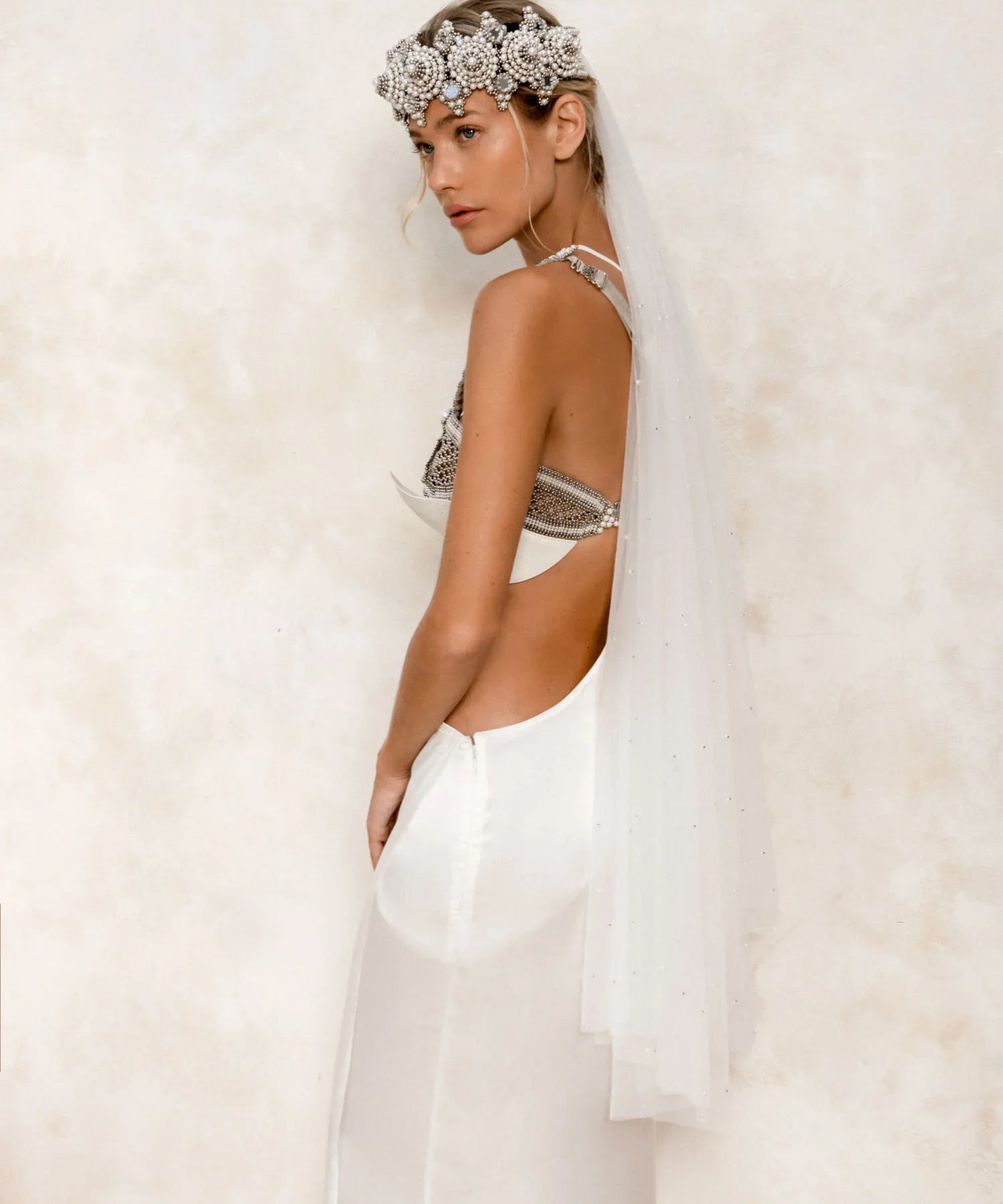 eingana modular crown with white harness skirt worn on woman by object and dawn at neutral background side view