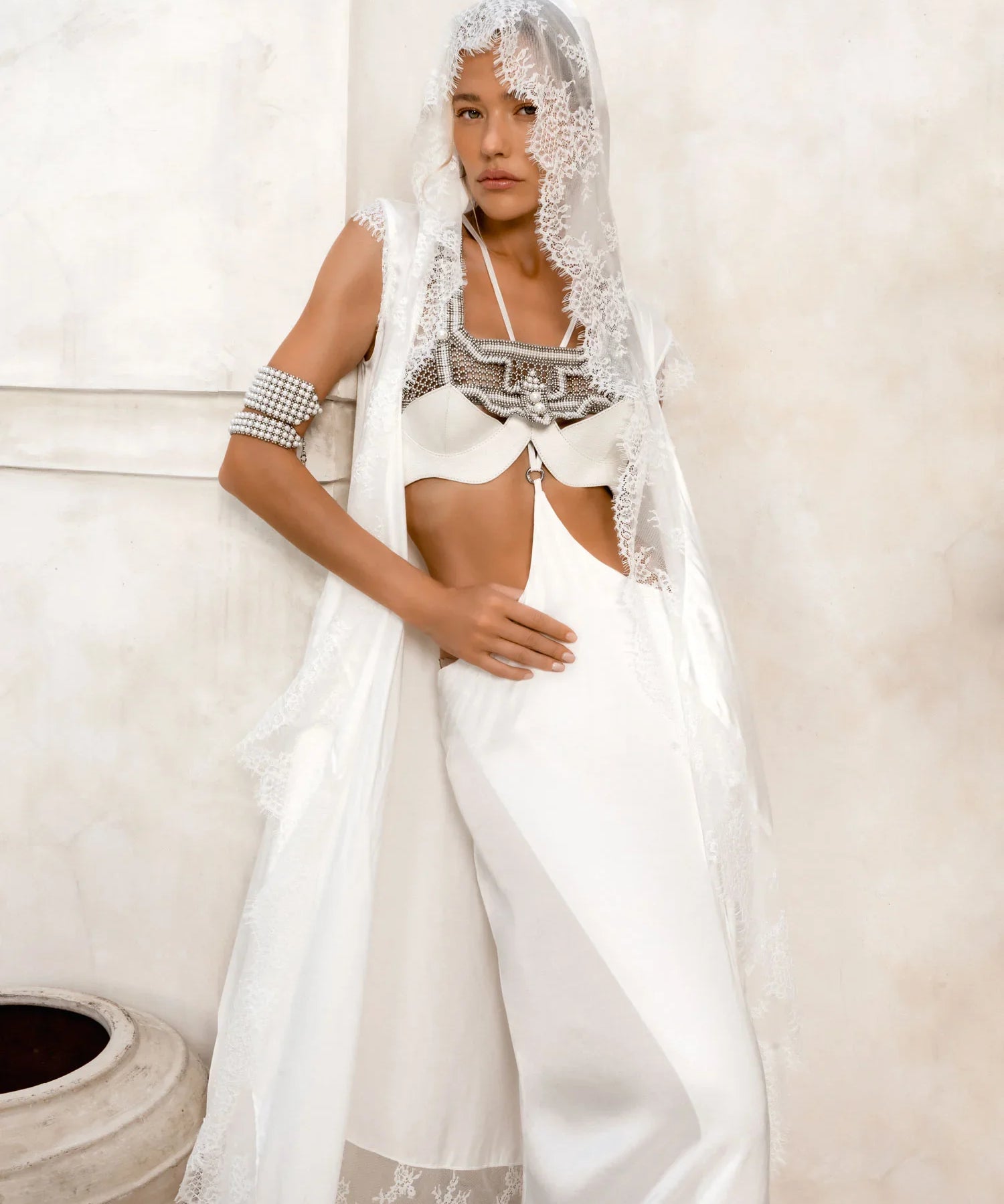woman wear bride oufit in white robe lace with handcrafted modular beads crown and harness in pearl by object and dawn
