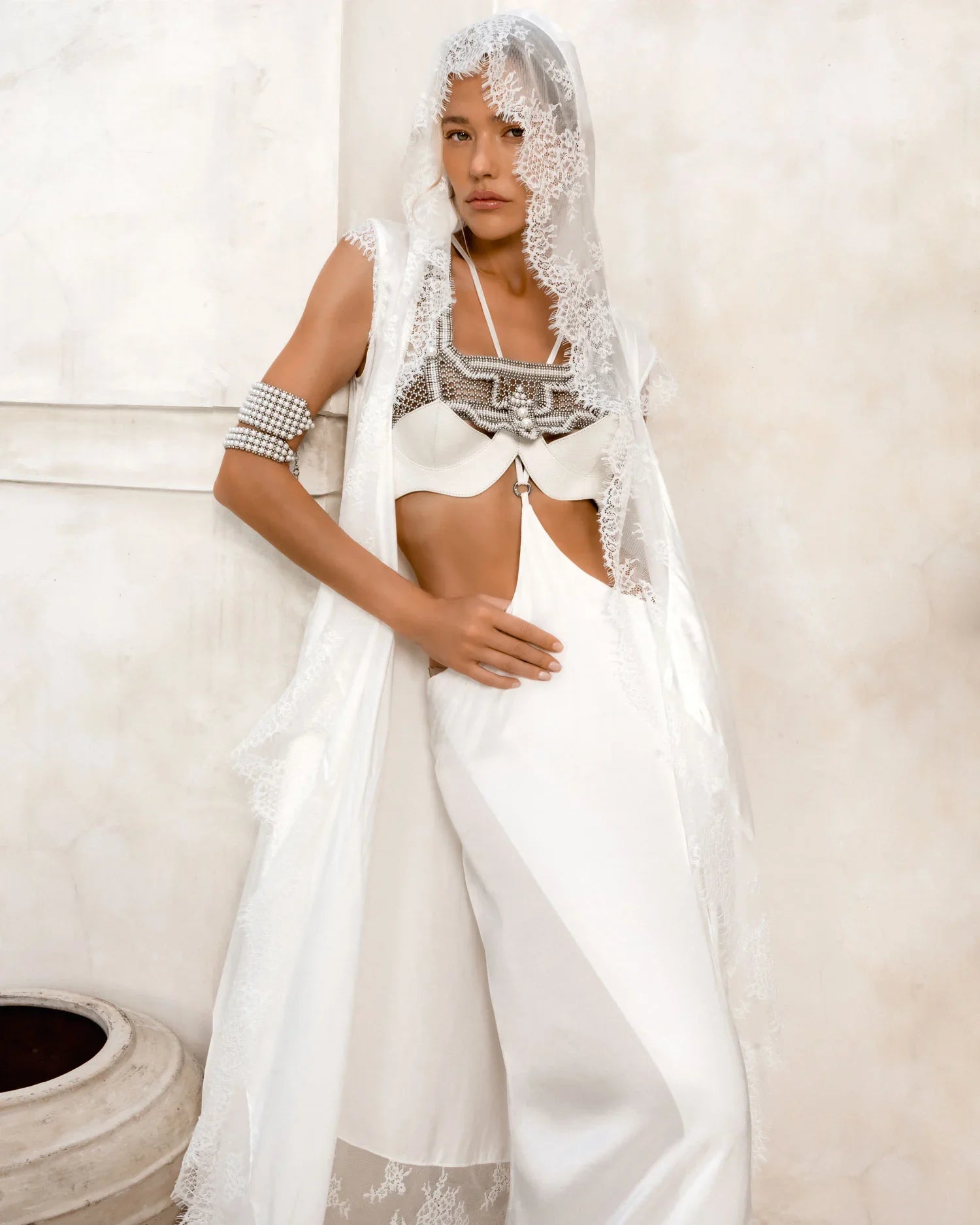 woman wear bride oufit in white robe lace with handcrafted modular beads crown and harness in pearl by object and dawn