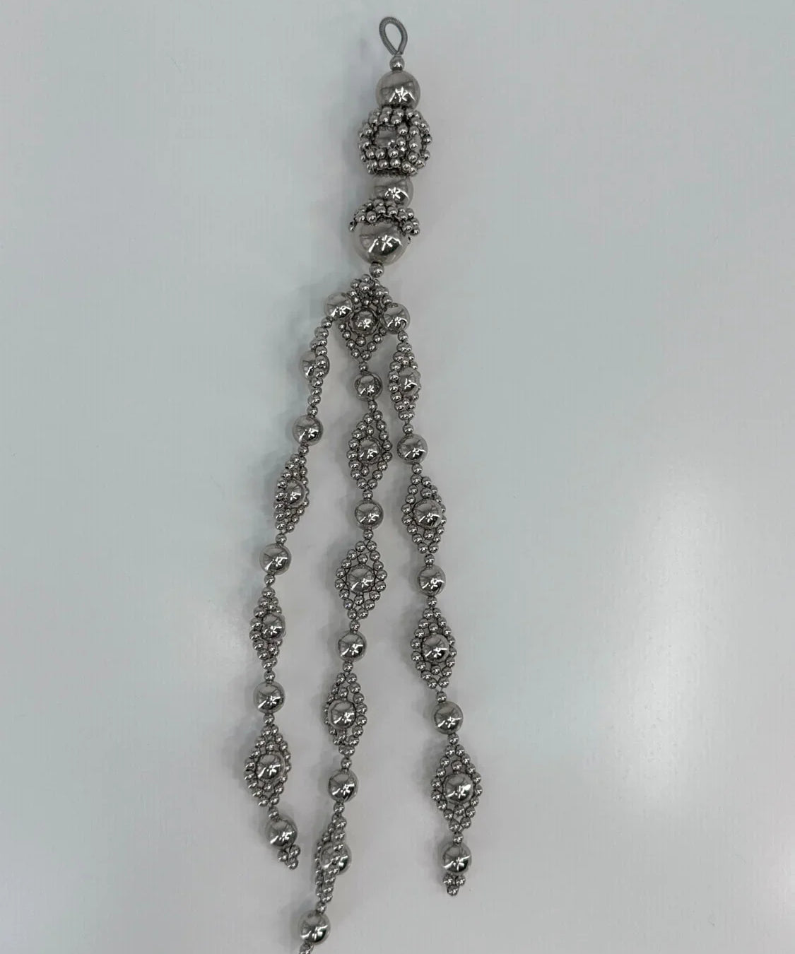 Beaded medallion from polymer metal beads by object and dawn on neutral background