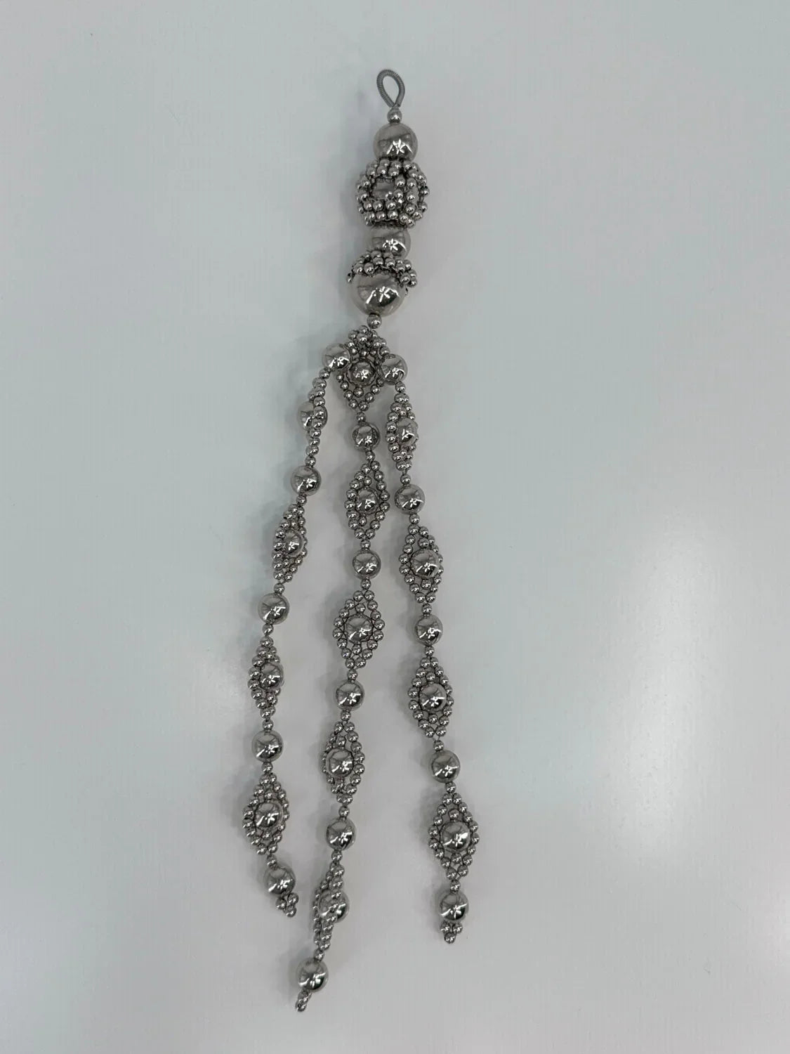 Beaded medallion from polymer metal beads by object and dawn on neutral background