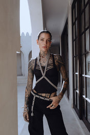 woman in black pants wearing V neck beaded harness w collar silver by object & dawn in white building