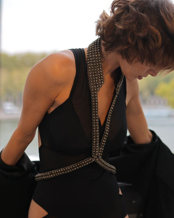 Woman in a black dress with V-Neck Beaded Harness, leaning against a railing with the Eiffel Tower in the background.