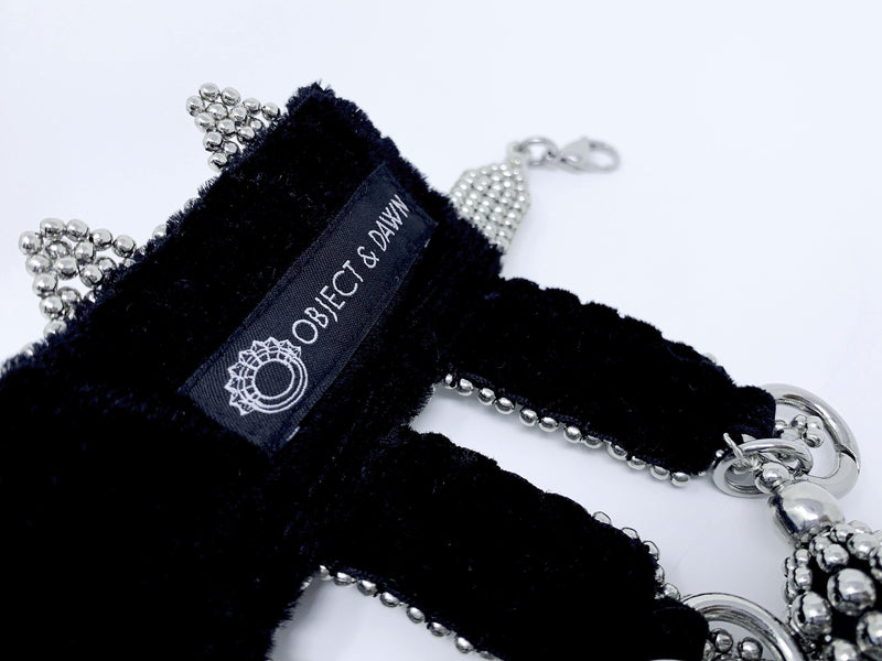 Eingana Choker with Removable Tassels by Object and Dawn is constructed entirely by hand with high quality metal beads that coated in polymer to preserve shine and ensure the item is hypoallergenic.  Ethically made with secret ancient techniques by our skilled artisans.  Accented with removable black polyester tassels. Fully lined in velvet for your ultimate comfort.