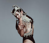 Hera Modular Harness by Object and Dawn is constructed with high quality metal beads that are coated in polymer to preserve shine and ensure the item is hypoallergenic.  Ethically made with secret ancient techniques by our skilled artisans, each piece takes several days to make. The harness is accented with hand cut mirror clusters, locally harvested cowrie shells, custom metal chain tassels and intricate black crystals.  This piece is fully lined by hand in luxurious velvet for your ultimate comfort.